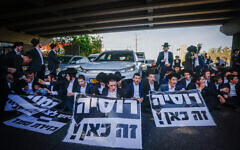 Ultra-Orthodox Jews block a road and clash with police during a protest against the drafting of Haredim to the Israeli army, on Route 4, outside the city of Bnei Brak, April 1, 2024. (Chaim Goldberg/Flash90)