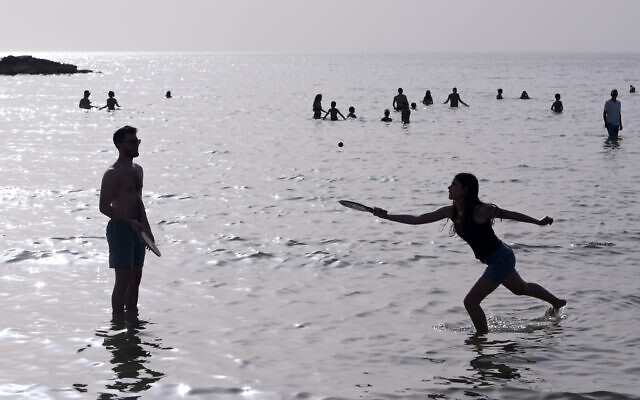 Israelis enjoying the beach in Tel Aviv during a heatwave, on April 24, 2024. (Avshalom Sassoni/Flash90)
