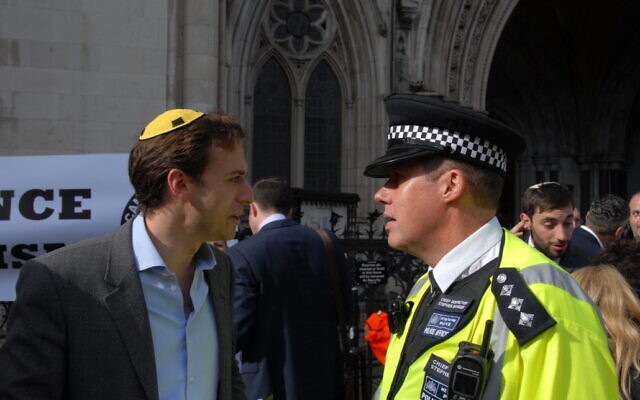Gideon Falter, left, speaks to a chief police inspector at a Campaign Against Antisemitism rally in this undated photo taken in London. The photo was not taken on Saturday, April 13, when Falter was told to leave a central London neighborhood where an anti-Israel demonstration was taking place. (Courtesy of the CAA)