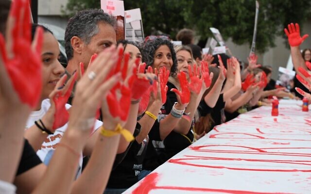 In a photo released by anti-government activists, relatives of hostages show red hands representing symbolizing the blood on the government's hands for so far not securing a deal to release the captives held by Hamas in Gaza, at Hostages Square, in Tel Aviv, April 27, 2024. (Paulina Patimer)