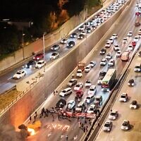Families of hostages and their supporters block the Ayalon Highway on April 27, 2024, as they demand a deal to release their loved ones. The Hebrew letter spells out the word "Enough. (Amir Goldstein: Pro-Democracy Protest Movement)