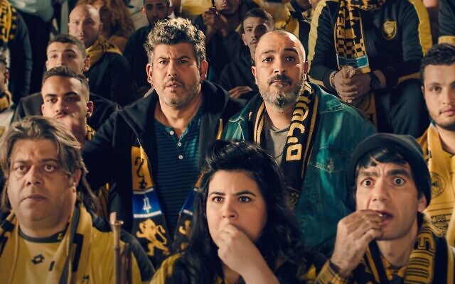Guy Amir (left) and Hanan Savyon at a Beitar Jerusalem soccer game in a scene from their new Netflix series 'Bros.' (Courtesy Netflix)