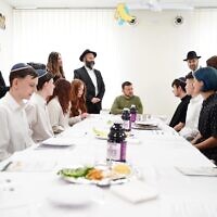 Ukrainian President Volodymyr Zelensky sits with students from the Simcha School in Kyiv for a model Passover seder, April 18, 2024. (Courtesy FJCU via JTA)