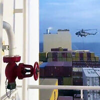 This image grab taken from a UGC video posted on social media on April 13, 2024, shows Iran's Revolutionary Guards rappelling down onto a container ship, MSC Aries, near the Strait of Hormuz. (Video screenshot)