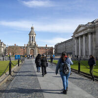 People walk around the grounds of Trinity College Dublin on March 12, 2020. (Paul Faith / AFP)