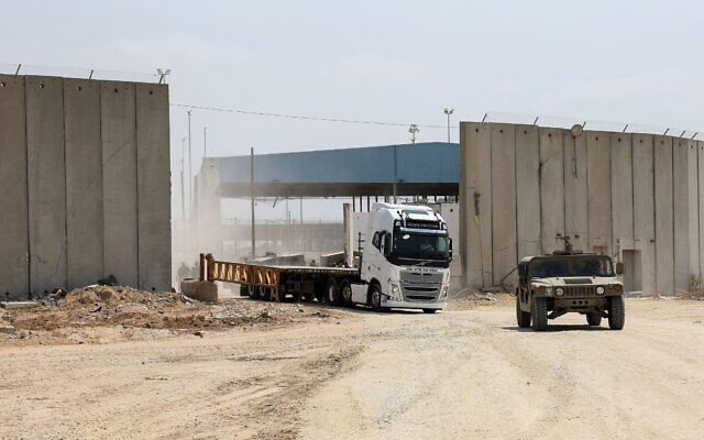 An Israeli military vehicle leads a truck in Beit Hanoun in the northern Gaza Strip during an operation to deliver humanitarian aid delivered from Jordan to the coastal territory through the Erez Crossing, on May 1, 2024. (Jack Guez/AFP)