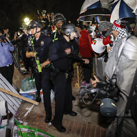 Police breach the pro-Palestinian, anti-Israel encampment at the campus of the University of California, Los Angeles (UCLA) in Los Angeles, California, early on May 2, 2024. (Etienne Laurent/AFP)