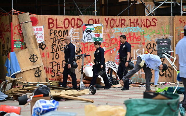 Illustrative: Police patrol as workers clean up anti-Israel graffiti at the University of California, Los Angeles (UCLA) campus after police evicted pro-Palestinian protesters, May 2, 2024. (Frederic J. Brown/AFP)