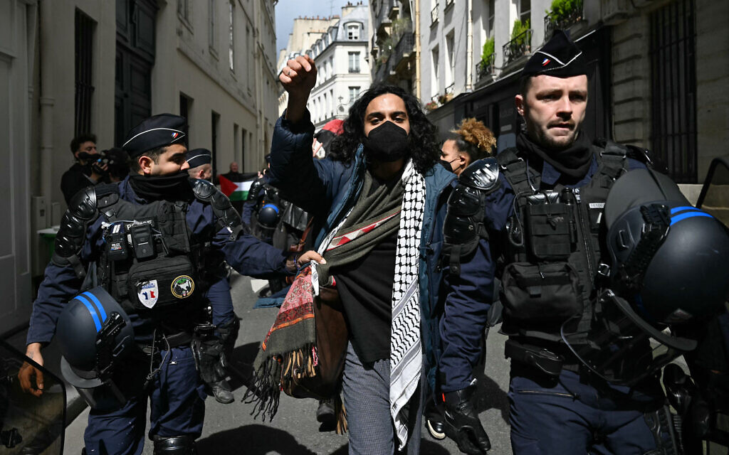 A pro-Palestinian protester is escorted away by French gendarmes during the evacuation of a sit-in in the entrance hall of the Institute of Political Studies (Sciences Po Paris) in Paris on May 3, 2024. (Miguel Medina/AFP)