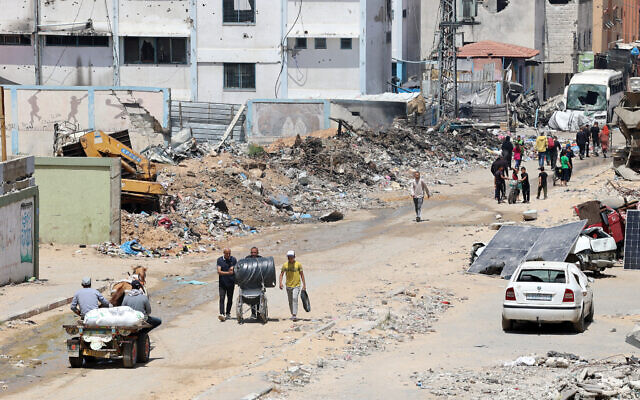 Palestinians walk with their belongings in Beit Lahya in the northern Gaza Strip on May 4, 2024, amid the ongoing conflict between Israel and Hamas. (AFP)