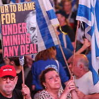 Israeli activists hold placards during an anti-government demonstration in Tel Aviv, on May 4, 2024. (JACK GUEZ / AFP)