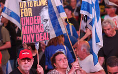 Israeli activists hold placards during an anti-government demonstration in Tel Aviv, on May 4, 2024. (JACK GUEZ / AFP)