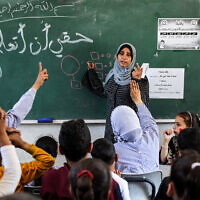 File: A woman instructs children on arithmetic multiplication in a classroom at a school run by the United Nations Relief and Works Agency for Palestine Refugees in the Near East (UNRWA) at the Shati camp for Palestinian refugees, west of Gaza City, on May 7, 2024. (AFP)