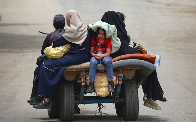 Palestinians sit on a cart as they move to safer areas in Rafah, in the southern Gaza Strip, on May 10, 2024. (AFP)