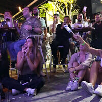 People watch the final results of the 68th Eurovision Song Contest (ESC) 2024 at a bar in Tel Aviv on May 12, 2024. (Sharon Aronowicz/AFPTV/AFP)