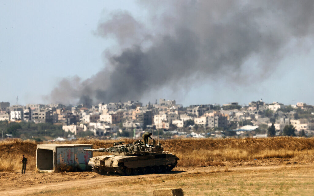 An Israeli tank is seen near the border with the Gaza Strip as smoke rises above the coastal enclave on May 15, 2024. (Jack Guez/AFP)