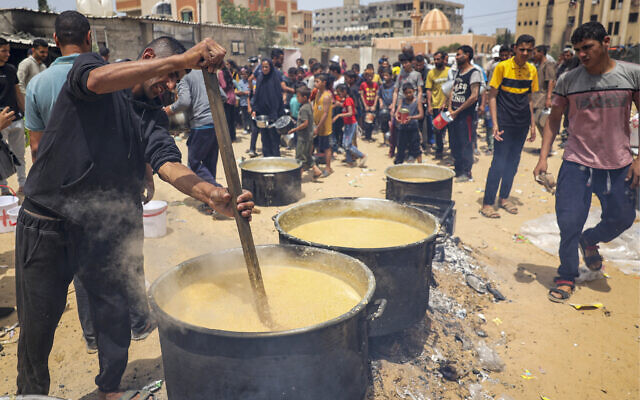 Volunteers prepare food for displaced Palestinians in Rafah, on the southern Gaza Strip, on May 19, 2024. (AFP)