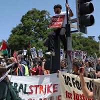 Illustrative: UC Santa Cruz workers who are union members of UAW 4811, which is part of the United Auto Workers, and pro-Palestinian protesters carry signs as they demonstrate in front of the UC Santa Cruz campus on May 20, 2024 in Santa Cruz, California. (Justin Sullivan/Getty Images/AFP)