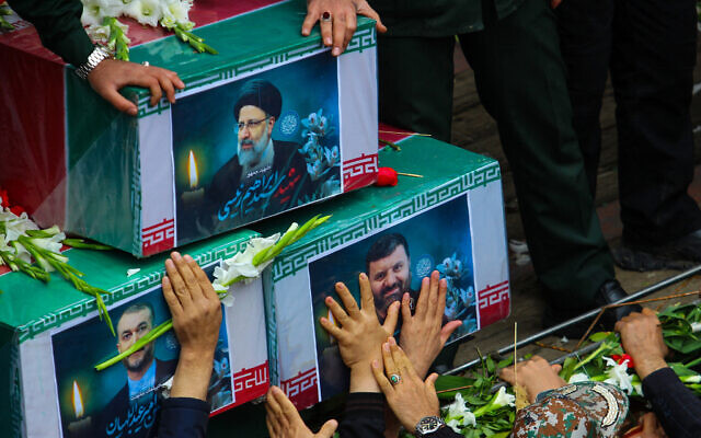 People participate in a funeral procession alongside a truck carrying the coffins of Iranian president Ebrahim Raisi and his seven aides in Tabriz, East Azerbaijan province, on May 21, 2024. (ATA DADASHI / FARS NEWS AGENCY / AFP)