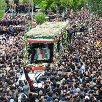 People participate in a funeral procession alongside a truck carrying the coffins of president Ebrahim Raisi and his seven aides in Tabriz, East Azerbaijan province, on May 21, 2024 (ATA DADASHI / MOJ News Agency / AFP)
