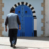 A Tunisian Jewish man walks in Hara Kebira, the main Jewish quarter in the resort island of Djerba, during the annual Jewish pilgrimage, on May 24, 2024. (Fethi Belaid / AFP)