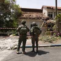 Soldiers inspecting the damage to a building in the northern community of Dovev, after it was hit by rockets fired from Lebanon, during an IDF tour, on May 27, 2024. (Jalaa Marey/ AFP)