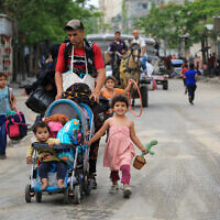 Palestinians flee the area of Tal al-Sultan in Rafah with their belongings on May 28, 2024. (Eyad Baba/AFP)