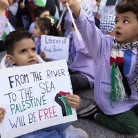 A Palestinian elementary student holds a placard reading 'From the river to the sea, Palestine will be free' as they attend a sit-in outside the office of the Delegation of the European Union to Lebanon, to show their solidarity with the Palestinian people in Gaza, in Beirut, Lebanon, December 14, 2023. (AP Photo/Hussein Malla)