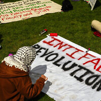 A person prepares a sign reading 'Intifada Revolution' at an anti-Israel encampment at the University of Washington campus, April 29, 2024, in Seattle, Washington. (AP Photo/Lindsey Wasson)