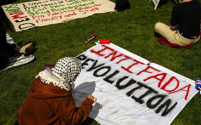 A person prepares a sign reading 'Intifada Revolution' at an anti-Israel encampment at the University of Washington campus, April 29, 2024, in Seattle, Washington. (AP Photo/Lindsey Wasson)