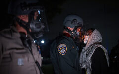 A protester confronts police as demonstrators clash at an anti-Israel, pro-Palestinian encampment at UCLA Wednesday, May 1, 2024, in Los Angeles. (AP Photo/Ethan Swope)