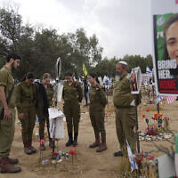 Soldiers observe two minutes of silence for victims of the Holocaust, at a makeshift memorial for those killed and kidnapped on Oct. 7, 2023 in a cross-border attack by Hamas at the Nova music festival, in Re'im, May 6, 2024 (AP Photo/Tsafrir Abayov)