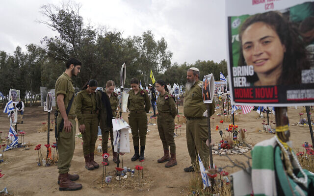 Soldiers pray observe two-minutes silence for victims of the Holocaust, at a makeshift memorial for those killed and kidnapped on Oct. 7, 2023 in a cross-border attack by Hamas at the Nova music festival, in Re'im, May 6, 2024 (AP Photo/Tsafrir Abayov)