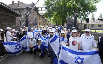 People holding Israeli flags pose for a photo at Auschwitz-Birkenau in Oswiecim, Poland, May 6, 2024 during the annual Holocaust remembrance event, the 'March of the Living' in memory of the six million Jewish victims of the Holocaust victims. (AP Photo/Czarek Sokolowski)