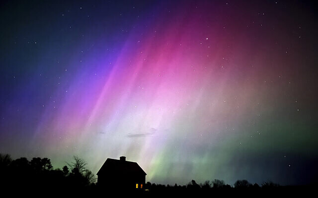 The northern lights flare in the sky over a farmhouse, May 10, 2024, in Brunswick, Maine. (AP Photo/Robert F. Bukaty)