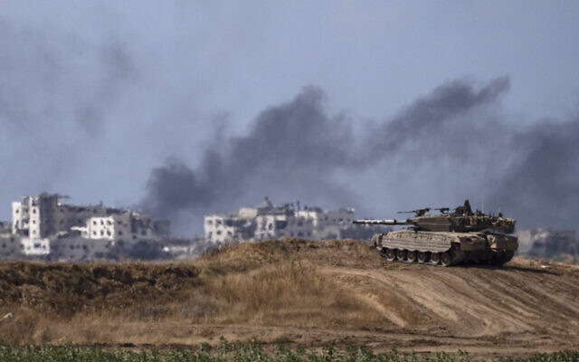 Backdropped by smoke rising to the sky after an explosion in the Gaza Strip, an Israeli tank stands near the Israel-Gaza border as seen from southern Israel, Monday, May 13, 2024. (AP/Leo Correa)
