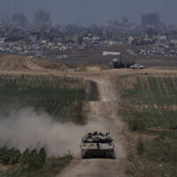 Israeli soldiers move on the top of a tank near the Israeli-Gaza border, as seen from southern Israel, May 16, 2024. (AP Photo/Leo Correa)