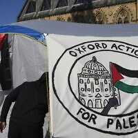 A pro-Palestinian student walks in a tent outside the Pitt Rivers Museum in Oxford, England, May 9, 2024. (AP/Kin Cheung)