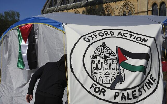 A pro-Palestinian student walks in a tent outside the Pitt Rivers Museum in Oxford, England, May 9, 2024. (AP Photo/Kin Cheung, File)