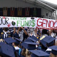 George Washington University students carry a sign during an anti-Israel protest as George Washington University President Ellen Granberg speaks at a commencement ceremony in Washington, May 19, 2024. (AP Photo/Jose Luis Magana)
