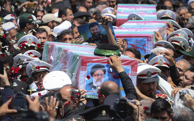 Flag-draped coffins of Iranian President Ebrahim Raisi and his companions who were killed in a helicopter crash are carried during their funeral ceremony in the city of Mashhad, Iran, May 23, 2024.(Iranian Presidency Office via AP)