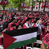 A student holds up the Palestinian flag as the 13 students, who have been barred from graduating due to protest activities, are recognized by a student address speaker during the commencement in Harvard Yard at Harvard University, May 23, 2024, in Cambridge, Massachusetts. (AP Photo/Charles Krupa)