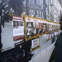 A man looks at a poster of Oryon Hernandez Radoux, 30, second left, who was killed on October 7, 2023, next to posters of hostages held by Hamas in the Gaza Strip, in central Jerusalem, May 24, 2024. (AP Photo/Mahmoud Illean)
