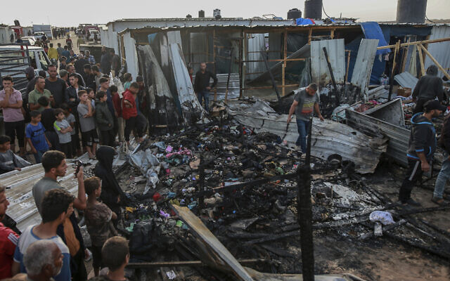 Palestinians look at the destruction after an Israeli strike on what the IDF said was a Hamas compound, adjacent to a camp for internally displaced people in Rafah, Gaza Strip, May 27, 2024. (AP Photo/Jehad Alshrafi)