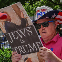 A supporter of former President Donald Trump reads a 'Jews for Trump' sign outside Manhattan Criminal Court, on May 29, 2024, in New York. (AP/Julia Nikhinson)