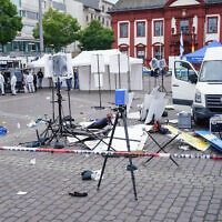 Forensics officers stand behind a smashed stall on the market square in Mannheim, Germany, May 31, 2024. (Uwe Anspach/dpa via AP)