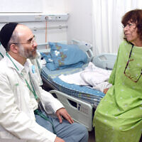 Chaplain Baruch Siris visits with patient Clara Stofkooper at Soroka Medical Center in Beersheba, Israel, in this recent undated photo. (Courtesy/ Dina Frenkel)