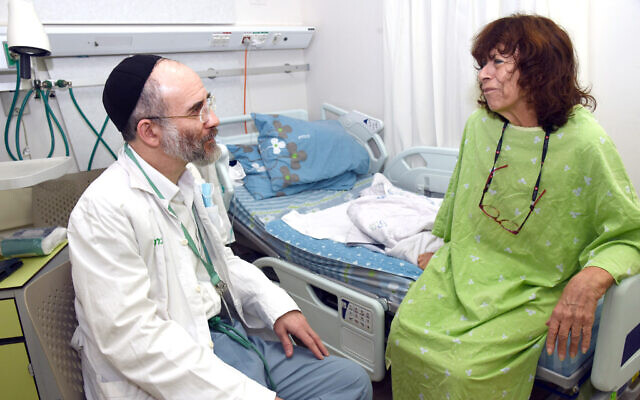 Chaplain Baruch Siris visits with patient Clara Stofkooper at Soroka Medical Center in Beersheba, Israel, in this recent undated photo. (Courtesy/ Dina Frenkel)