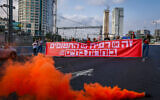 Protesters hold a banner reading "It's either Rafah or the hostages: Choose life" as they block the Ayalon Highway in Tel Aviv during a demonstration calling for the release of the hostages held by Hamas in Gaza, May 2, 2024. (Dor Pazuelo/Flash90)