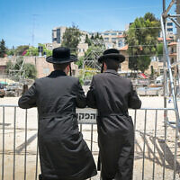 Haredi Jews watch preperations for the Lag B'Omer festivities at the Shimon HaTzadik tomb in Jerusalem on May 22, 2024. (Photo by Arie Leib Abrams/FLASH90)